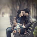 Couple kissing at the bench at alley.